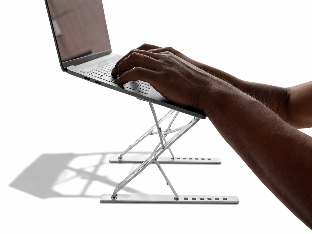 Person typing on laptop elevated by Stelo aluminum laptop stand